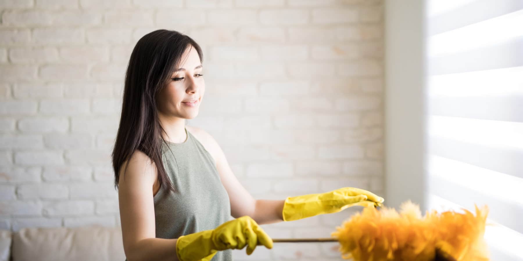 Woman using a swiffer eliminate dust mites.