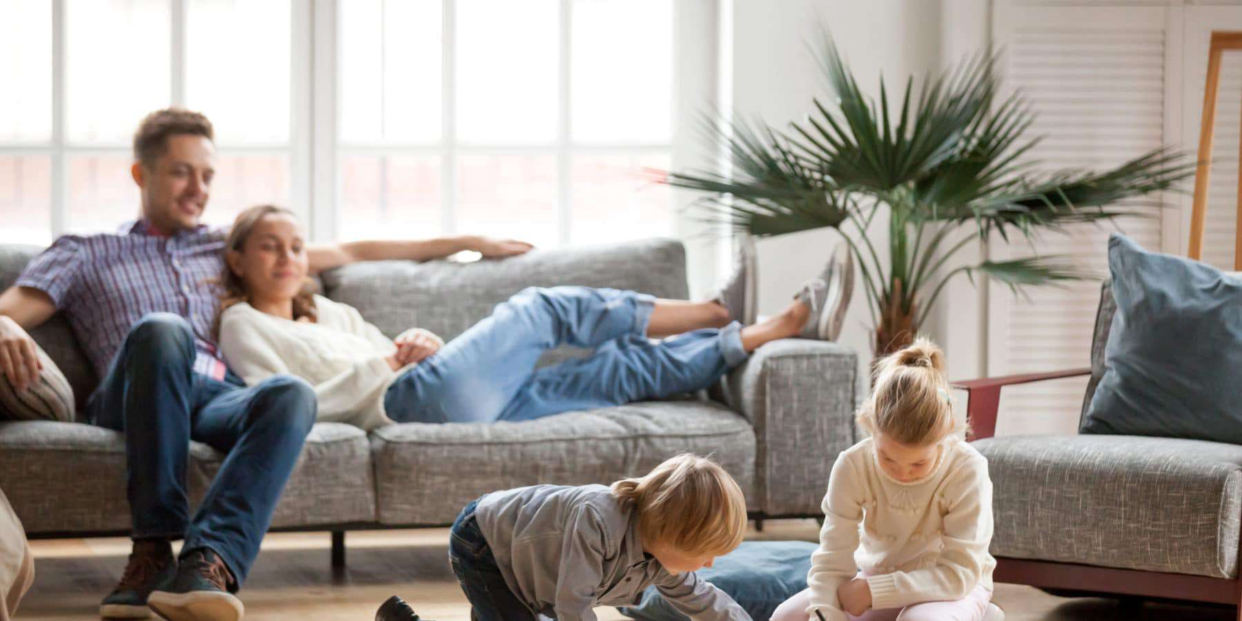 Happy and healthy family sitting and playing in a living room.